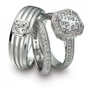 Two platinum engagement rings and a platinum wedding band