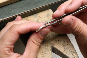 Jeweler replacing a stone in a diamond wedding band